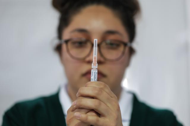 (251112) -- MEXICO CITY, Nov. 12, 2025 (Xinhua) -- A health worker prepares to administer a vaccine at a vaccination center in Mexico City, capital of Mexico, Nov. 12, 2025. Mexico City has set up a vaccination center offering influenza, COVID-19, pneumococcal and measles vaccines to the public as part of efforts to improve community immunization coverage during the winter season. (Photo by Francisco Canedo/Xinhua)