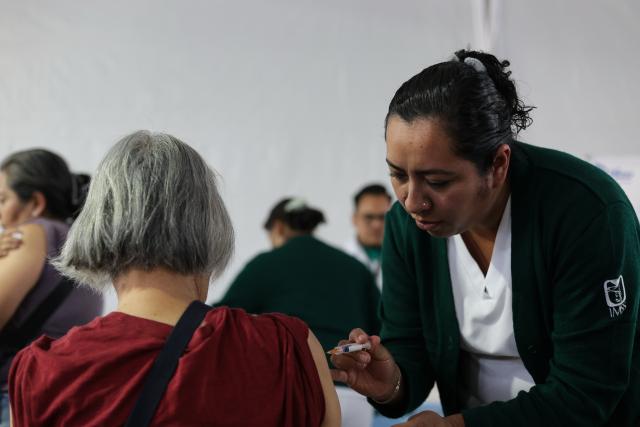 (251112) -- MEXICO CITY, Nov. 12, 2025 (Xinhua) -- A health worker administers a vaccine to a woman at a vaccination center in Mexico City, capital of Mexico, Nov. 12, 2025. Mexico City has set up a vaccination center offering influenza, COVID-19, pneumococcal and measles vaccines to the public as part of efforts to improve community immunization coverage during the winter season. (Photo by Francisco Canedo/Xinhua)