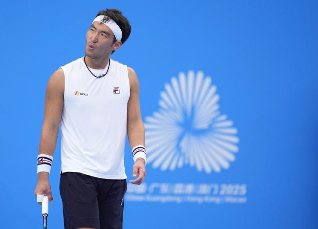 (251113) -- HENGQIN, Nov. 13, 2025 (Xinhua) -- Bu Yunchaokete reacts during the men's singles first round match of tennis between Bu Yunchaokete of Zhejiang and Sun Qian of Jiangsu at China's 15th National Games in Hengqin, south China's Guangdong Province, Nov. 13, 2025. (Xinhua/Yan Linyun)