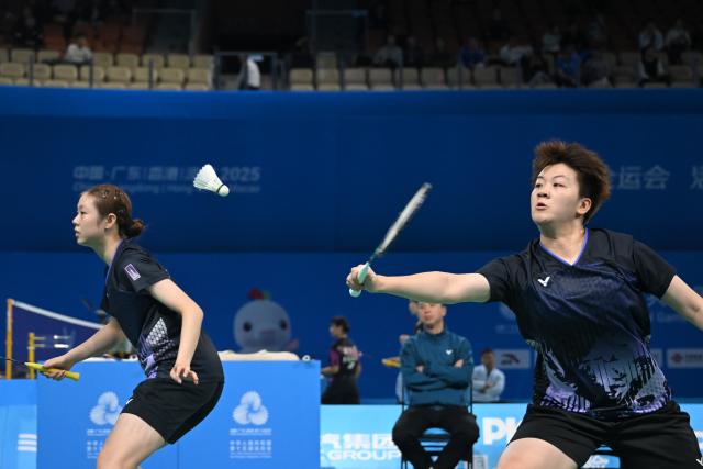 (251113) -- SHENZHEN, Nov. 13, 2025 (Xinhua) -- Cao Zihan (R)/Qian Ziyi of Shanghai compete against Xiao Yu/Li Keyu of Sichuan during the U18 women's team bronze medal match of badminton between Shanghai and Sichuan at China's 15th National Games in Shenzhen, south China's Guangdong Province, Nov. 13, 2025. (Xinhua/Zhang Long)