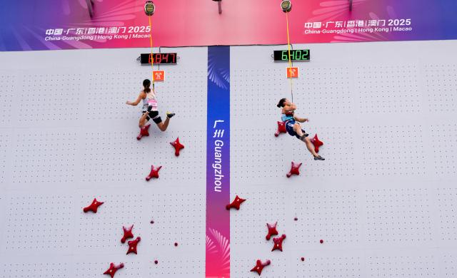 (251113) -- GUANGZHOU, Nov. 13, 2025 (Xinhua) -- Deng Lijuan (R) of Hunan and Zhang Mengli of Shandong compete during the women's speed qualification of sport climbing at China's 15th National Games in Guangzhou, south China's Guangdong Province, Nov. 13, 2025. (Xinhua/Jigme Dorji)
