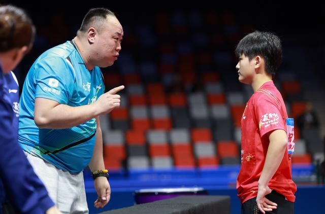 (251113) -- MACAO, Nov. 13, 2025 (Xinhua) -- Coach of team Beijing instructs Zhu Qihui (R) of Beijing in the match against Jiang Yiyi of Shandong during U18 women's team final match of table tennis between Beijing and Shandong at China's 15th National Games in Macao, south China, Nov. 13, 2025. (Xinhua/Liang Xu)
