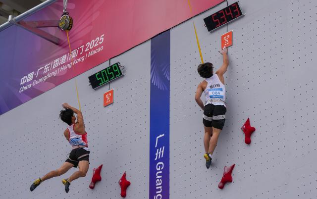 (251113) -- GUANGZHOU, Nov. 13, 2025 (Xinhua) -- Yang Jie (L) of Yunnan and Huang Riming of Guangxi compete during the men's speed qualification of sport climbing at China's 15th National Games in Guangzhou, south China's Guangdong Province, Nov. 13, 2025. (Xinhua/Jigme Dorji)