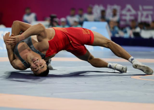 (251113) -- QINGYUAN, Nov. 13, 2025 (Xinhua) -- Liu Rui (R) of Shandong competes against Bahejiang Halishan of Xinjiang during the men's Greco Roman 77kg final of wrestling at China's 15th National Games in Qingyuan, south China's Guangdong Province, Nov. 13, 2025. (Xinhua/Li Ran)