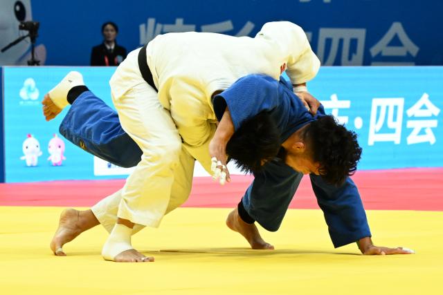 (251113) -- ZHAOQING, Nov. 13, 2025 (Xinhua) -- Wang Youliang (L) of Shandong competes against Qing Daga of Inner Mongolia during the Judo mixed team final between Shandong and Inner Mongolia at China's 15th National Games in Zhaoqing, south China's Guangdong Province, Nov. 13, 2025. (Xinhua/Zhu Xiang)