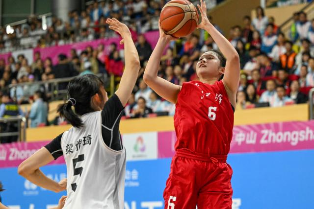 (251113) -- ZHONGSHAN, Nov. 13, 2025 (Xinhua) -- Li Yuanshan (R) of Jiangsu shoots the ball during the U18 women's final match of basketball between Shandong and Jiangsu at China's 15th National Games in Zhongshan, south China's Guangdong Province, Nov. 13, 2025. (Xinhua/Ding Lei)