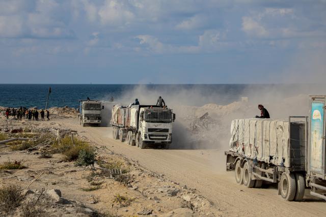 (251113) -- GAZA, Nov. 13, 2025 (Xinhua) -- Photo taken on Nov. 13, 2025 shows trucks that carry commercial goods and enter through the Zikim crossing in northern Gaza Strip. Israel said on Wednesday it has reopened the Zikim crossing to allow humanitarian aid trucks into northern Gaza. (Photo by Rizek Abdeljawad/Xinhua)