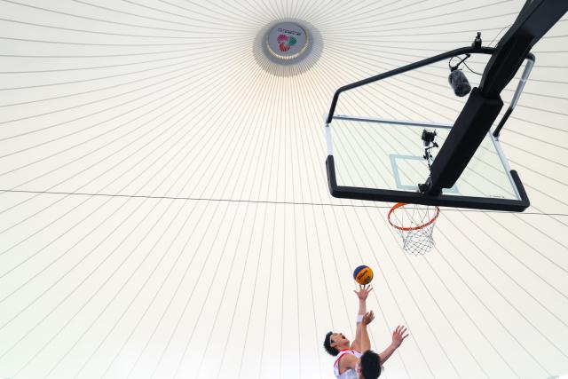 (251114) -- BEIJING, Nov. 14, 2025 (Xinhua) -- Wang Zhelin (L) of Fujian goes for a layup during the group B match of men's 3X3 basketball at China's 15th National Games in Macao, south China, Nov. 13, 2025. (Xinhua/Cheong Kam Ka)