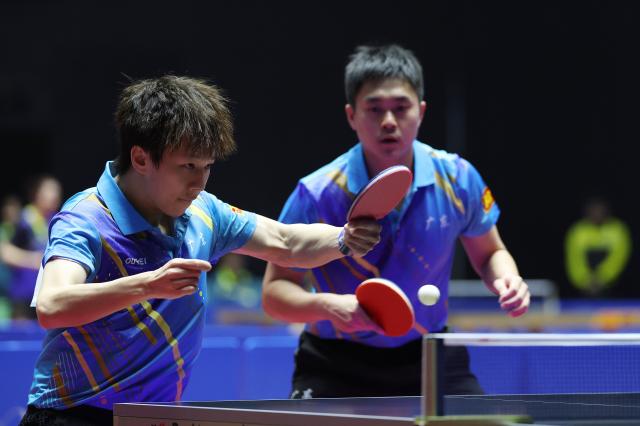 (251114) -- MACAO, Nov. 14, 2025 (Xinhua) -- Lin Gaoyuan (front)/Li Yijie of Guangdong compete against Sun Zheng/Cai Wei of Zhejiang during the men's team group C match of table tennis between Guangdong and Zhejiang at China's 15th National Games Macao, south China, Nov. 14, 2025. (Xinhua/Sun Fanyue)