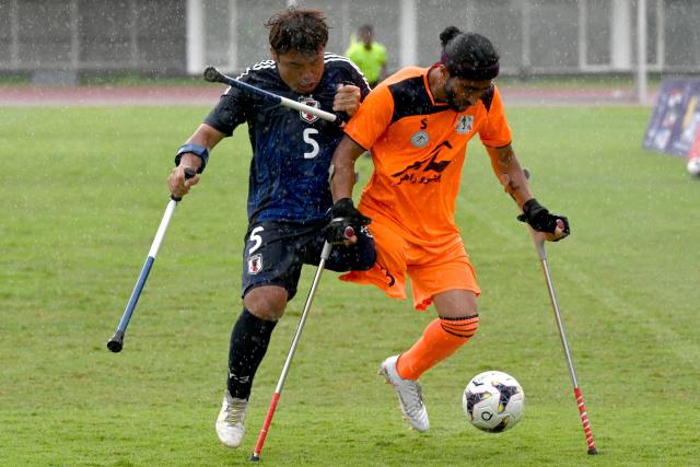 (251114) -- JAKARTA, Nov. 14, 2025 (Xinhua) -- Yusuke Matsuzaki (L) of Japan vies with Yadolah Gholami Zali of Iran during the match between Iran and Japan at the Asian Amputee Football Cup Qualifiers 2025 in Jakarta, Indonesia, Nov. 14, 2025. (Xinhua/Agung Kuncahya B.)