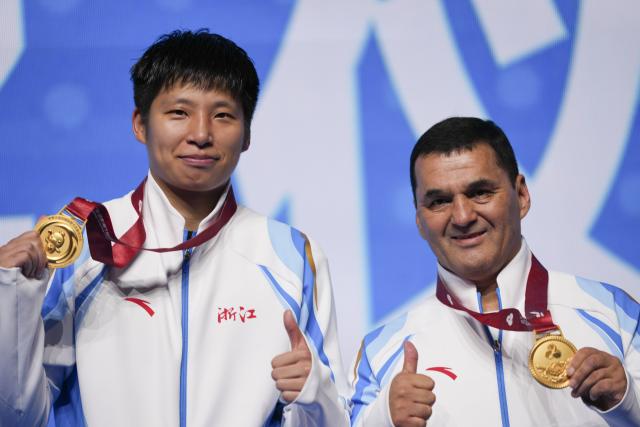 (251114) -- SHENZHEN, Nov. 14, 2025 (Xinhua) -- Gold medalist Ye Jin (L) of Zhejiang poses with her coach during the awarding ceremony for the women's 75kg of boxing at China's 15th National Games in Shenzhen, south China's Guangdong Province, Nov. 14, 2025. (Xinhua/Peng Yikai)