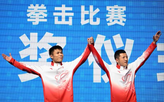 (251114) -- SHENZHEN, Nov. 14, 2025 (Xinhua) -- Gold medalist Zhu Jianhao (L) of Guangdong reacts during the awarding ceremony for the men's 63.5kg of boxing at China's 15th National Games in Shenzhen, south China's Guangdong Province, Nov. 14, 2025. (Xinhua/Yang Guanyu)