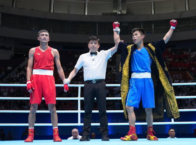 (251114) -- SHENZHEN, Nov. 14, 2025 (Xinhua) -- Zhu Jianhao (R) of Guangdong celebrates after defeating Yibulayimu Mamuti (L) of Xinjiang in the men's 63.5kg final of boxing at China's 15th National Games in Shenzhen, south China's Guangdong Province, Nov. 14, 2025. (Xinhua/Peng Yikai)