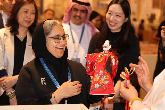 (251114) -- RIYADH, Nov. 14, 2025 (Xinhua) -- A guest views a puppet at the China Pavilion of the third edition of the Saudi International Handicrafts Week (Banan) in Riyadh, Saudi Arabia, Nov. 13, 2025.
  The third edition of the Saudi International Handicrafts Week (Banan) opened Thursday at Princess Nourah bint Abdulrahman University in the Saudi capital of Riyadh.
  China, this year's guest of honor, has set up a special pavilion decorated in vibrant red, featuring a wide range of Chinese intangible cultural heritage projects, including traditional lacquerware, fan-making craft, and the batik fabrics technique. (Xinhua/Wang Haizhou)