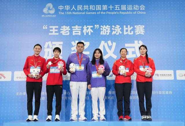 (251114) -- SHENZHEN, Nov. 14, 2025 (Xinhua) -- Gold medalist Chen Luying of Fujian, silver medalist Yu Zidi of Hebei and bronze medalist Zhang Yufei of Jiangsu pose with their coaches during the awarding ceremony for the women's 200m butterfly of swimming event at China's 15th National Games in Shenzhen, south China's Guangdong Province, Nov. 14, 2025. (Xinhua/Xue Yuge)