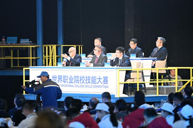 (251114) -- TIANJIN, Nov. 14, 2025 (Xinhua) -- Guests comment on competitors' performance during the World Vocational College Skills Competition 2025 in Tianjin, north China, Nov. 14, 2025. Six teams participated in the final of this competition here on Friday, with the one from Jinhua University of Vocational Technology garnering the championship. (Xinhua/Zhao Zishuo)