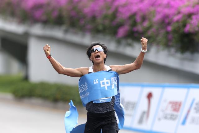 (251115) -- SHENZHEN, Nov. 15, 2025 (Xinhua) -- He Jie of Ningxia crosses the finish line during the men's marathon event at China's 15th National Games in Shenzhen, south China's Guangdong Province, Nov. 15, 2025. (Xinhua/Ding Ting)