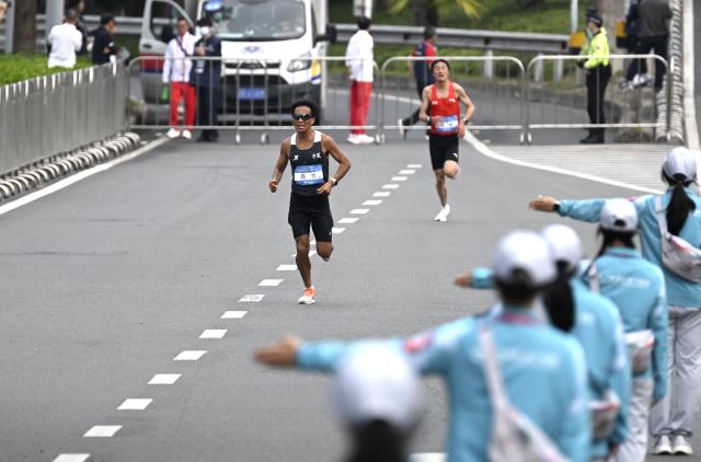 (251115) -- SHENZHEN, Nov. 15, 2025 (Xinhua) -- He Jie (front) of Ningxia competes during the men's marathon event at China's 15th National Games in Shenzhen, south China's Guangdong Province, Nov. 15, 2025. (Xinhua/Lian Zhen)