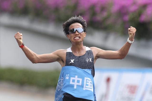 (251115) -- SHENZHEN, Nov. 15, 2025 (Xinhua) -- He Jie of Ningxia celebrates after crossing the finish line during the men's marathon event at China's 15th National Games in Shenzhen, south China's Guangdong Province, Nov. 15, 2025. (Xinhua/Ding Ting)