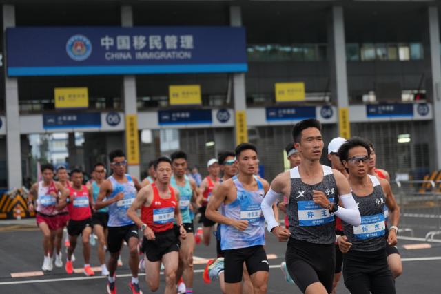 (251115) -- SHENZHEN, Nov. 15, 2025 (Xinhua) -- Athletes compete during the men's marathon event at China's 15th National Games in Shenzhen, south China's Guangdong Province, Nov. 15, 2025. (Xinhua/Tenzin Nyida)