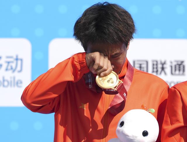 (251115) -- SHENZHEN, Nov. 15, 2025 (Xinhua) -- Gold medalist He Jie of Ningxia sheds tears during the awarding ceremony for the men's marathon event at China's 15th National Games in Shenzhen, south China's Guangdong Province, Nov. 15, 2025. (Xinhua/Jiang Han)