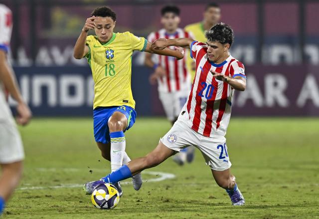 (251115) -- DOHA, Nov. 15, 2025 (Xinhua) -- Vinicius Rocha (L) of Brazil vies with Pedro Villalba of Paraguay during the round of 32 football match between Brazil and Paraguay at FIFA U17 World cup Qatar 2025 in Doha, Qatar, on Nov. 14, 2025. (Photo by Nikku/Xinhua)