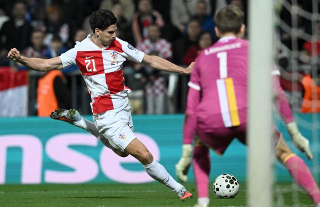 (251115) -- RIJEKA, Nov. 15, 2025 (Xinhua) -- Igor Matanovic (L) of Croatia shoots during the FIFA World Cup 2026 qualifier match between Croatia and the Faroe Islands in Rijeka, Croatia, on Nov. 14, 2025. (Marko Lukunic/PIXSELL via Xinhua)