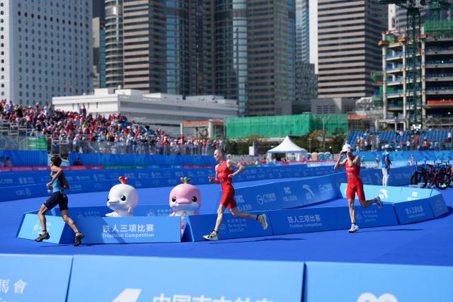 (251115) -- HONG KONG, Nov. 15, 2025 (Xinhua) -- Oscar Coggins (C) of Hong Kong competes during the men's individual triathlon at China's 15th National Games in Hong Kong, south China, Nov. 15, 2025. (Xinhua/Wu Lu)