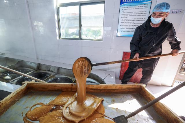 (251115) -- YIWU, Nov. 15, 2025 (Xinhua) -- A sugar factory worker airs brown sugar syrup in Shangyang Village of Yiwu City, east China's Zhejiang Province, Nov. 15, 2025.
  Boasting a history of making brown sugar for more than 300 years, Yiwu is known as the "home of brown sugar." Processed via traditional methods involving iron pot boiling and firewood heating to ensure the purity of the sugar, the resulting sugar has a light yellow color with a hint of cyan. (Xinhua/Xu Yu)
