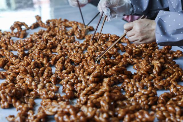 (251115) -- YIWU, Nov. 15, 2025 (Xinhua) -- This photo shows fried dough twist, known as Mahua, which here is made with brown sugar syrup, in Shangyang Village of Yiwu City, east China's Zhejiang Province, Nov. 15, 2025.
  Boasting a history of making brown sugar for more than 300 years, Yiwu is known as the "home of brown sugar." Processed via traditional methods involving iron pot boiling and firewood heating to ensure the purity of the sugar, the resulting sugar has a light yellow color with a hint of cyan. (Xinhua/Xu Yu)