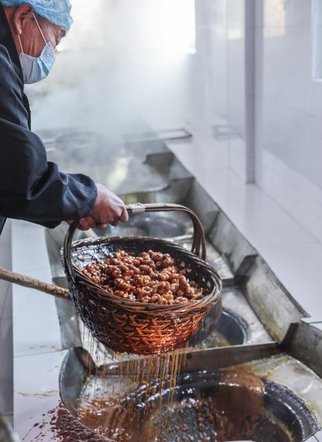 (251115) -- YIWU, Nov. 15, 2025 (Xinhua) -- A sugar factory worker cooks fried dough twist, known as Mahua, with brown sugar syrup in Shangyang Village of Yiwu City, east China's Zhejiang Province, Nov. 15, 2025.
  Boasting a history of making brown sugar for more than 300 years, Yiwu is known as the "home of brown sugar." Processed via traditional methods involving iron pot boiling and firewood heating to ensure the purity of the sugar, the resulting sugar has a light yellow color with a hint of cyan. (Xinhua/Xu Yu)