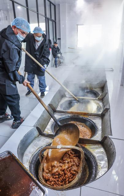 (251115) -- YIWU, Nov. 15, 2025 (Xinhua) -- Sugar factory workers cook fried dough twist, known as Mahua, with brown sugar syrup in Shangyang Village of Yiwu City, east China's Zhejiang Province, Nov. 15, 2025.
  Boasting a history of making brown sugar for more than 300 years, Yiwu is known as the "home of brown sugar." Processed via traditional methods involving iron pot boiling and firewood heating to ensure the purity of the sugar, the resulting sugar has a light yellow color with a hint of cyan. (Xinhua/Xu Yu)