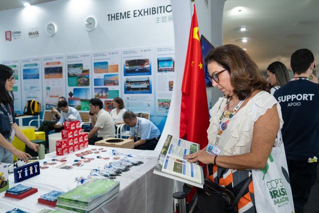 (251115) -- BELEM, Nov. 15, 2025 (Xinhua) -- A guest reads a brochure at the China Pavilion during the 30th United Nations climate change conference in Belem, Brazil, Nov. 12, 2025. The 30th United Nations climate change conference, commonly known as COP30, opened Monday in Belem, Brazil. Displays of Chinese cultural products, green technologies, and innovations attracted attention of the attendees during the conference. (Xinhua/Wang Tiancong)