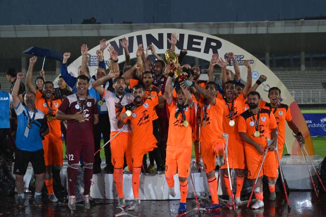 (251115) -- JAKARTA, Nov. 15, 2025 (Xinhua) -- Players of Iran hold trophy during the awarding ceremony after winning the final match between Uzbekistan and Iran at the Asian Amputee Football Cup Qualifiers 2025 in Jakarta, Indonesia, Nov. 15, 2025. (Xinhua/Agung Kuncahya B.)