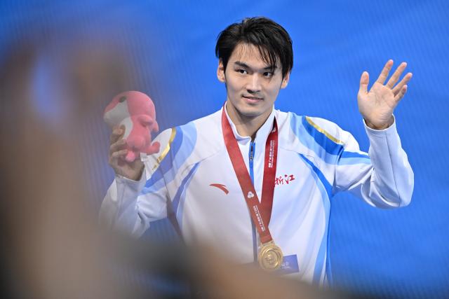 (251115) -- SHENZHEN, Nov. 15, 2025 (Xinhua) -- Gold medalist Xu Jiayu of Zhejiang greets the spectators after the awarding ceremony for the men's 200m backstroke of swimming at China's 15th National Games in Shenzhen, south China's Guangdong Province, Nov. 15, 2025. (Xinhua/Chen Yichen)