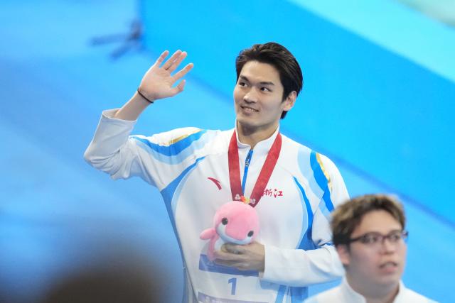 (251115) -- SHENZHEN, Nov. 15, 2025 (Xinhua) -- Gold medalist Xu Jiayu of Zhejiang greets the spectators after the awarding ceremony for the men's 200m backstroke of swimming at China's 15th National Games in Shenzhen, south China's Guangdong Province, Nov. 15, 2025. (Xinhua/Tenzin Nyida)