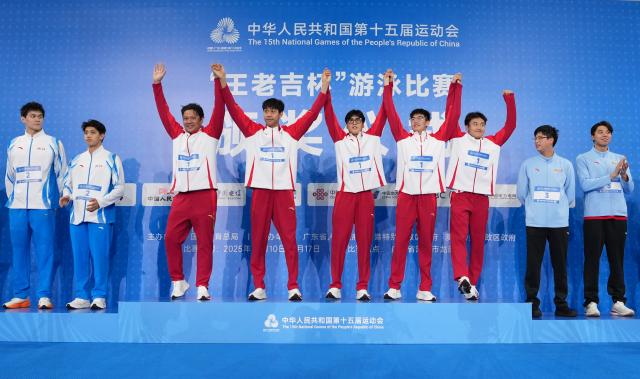 (251115) -- SHENZHEN, Nov. 15, 2025 (Xinhua) -- Gold medalists team Shandong and their coach wave during the awarding ceremony for the men's 4X200m freestyle relay of swimming at China's 15th National Games in Shenzhen, south China's Guangdong Province, Nov. 15, 2025. (Xinhua/Xia Yifang)