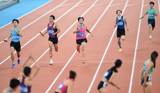 (251115) -- GUANGZHOU, Nov. 15, 2025 (Xinhua) -- Athletes compete during the mixed 4x400m relay final of athletics at China's 15th National Games in Guangzhou, south China's Guangdong Province, Nov. 15, 2025. (Xinhua/Deng Hua)