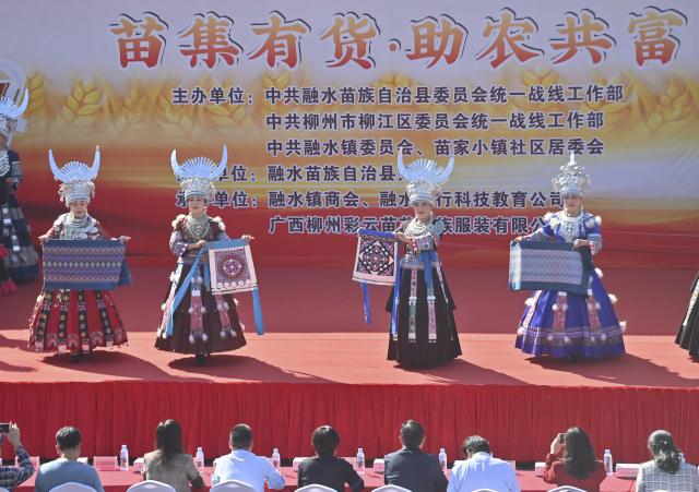 (251115) -- LIUZHOU, Nov. 15, 2025 (Xinhua) -- Actresses display embroideries and brocades of Miao ethnic group at an agricultural fair in Rongshui Miao Autonomous County, south China's Guangxi Zhuang Autonomous Region, Nov. 15, 2025. A Miao town community of Rongshui County held this fair to showcase and promote agricultural specialties and intangible cultural heritage from neighboring townships. (Xinhua/Huang Xiaobang)