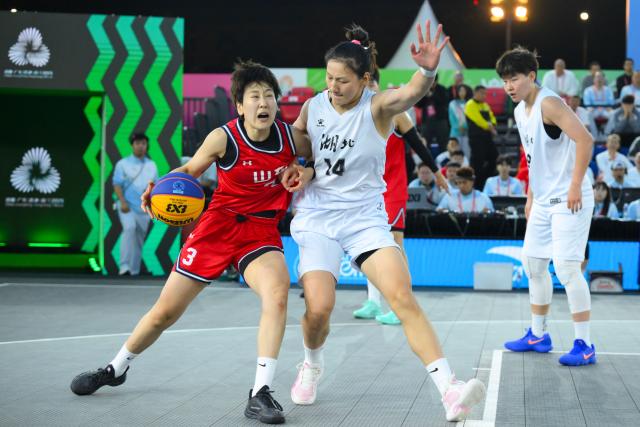 (251115) -- MACAO, Nov. 15, 2025 (Xinhua) -- Cao Junwei (L) of Shandong competes during the final match of women's 3x3 basketball between Hubei and Shandong at China's 15th National Games in Macao, south China, Nov. 15, 2025. (Xinhua/Cheong Kam Ka)