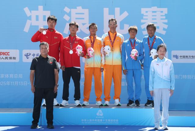 (251116) -- NAN'AO, Nov. 16, 2025 (Xinhua) -- Gold medalist Wu Shidong (3rd L, back) of Hainan, silver medalist Dong Zihao (2nd L, back) of Hebei and bronze medalist Jiang Shulou (2nd R, back) of Liaoning pose during the awarding ceremony for the men's shortboard surfing at China's 15th National Games in Nan'ao, south China's Guangdong Province, Nov. 16, 2025. (Xinhua/Lu Hanxin)