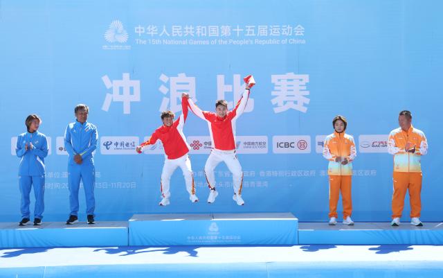 (251116) -- NAN'AO, Nov. 16, 2025 (Xinhua) -- Gold medalist Yang Siqi (3rd L) of Sichuan, silver medalist Jin Shuhan (1st L) of Liaoning and bronze medalist Deng Xueying (2nd R) of Hainan react during the awarding ceremony for the women's shortboard surfing at China's 15th National Games in Nan'ao, south China's Guangdong Province, Nov. 16, 2025. (Xinhua/Lu Hanxin)