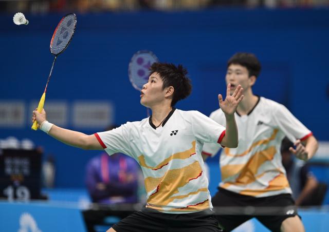 (251116) -- SHENZHEN, Nov. 16, 2025 (Xinhua) -- Ou Xuanyi/Huang Dongping (L) of Fujian compete during the mixed doubles round of 16 match of badminton against Tang Chun Man/Tse Ying Suet of Hong Kong at China's 15th National Games in Shenzhen, south China's Guangdong Province, Nov. 16, 2025. (Xinhua/Li Ziheng)