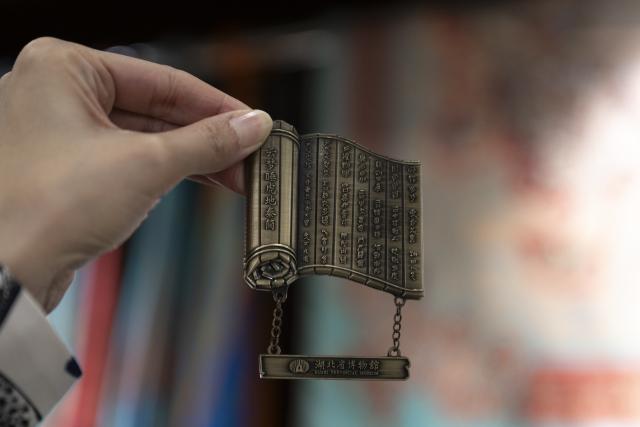 (251116) -- WUHAN, Nov. 16, 2025 (Xinhua) -- A visitor shows a fridge magnet inspired by bamboo slips at the Hubei Provincial Museum in Wuhan, central China's Hubei Province, Oct. 21, 2025. (Xinhua/Wu Zhizun)