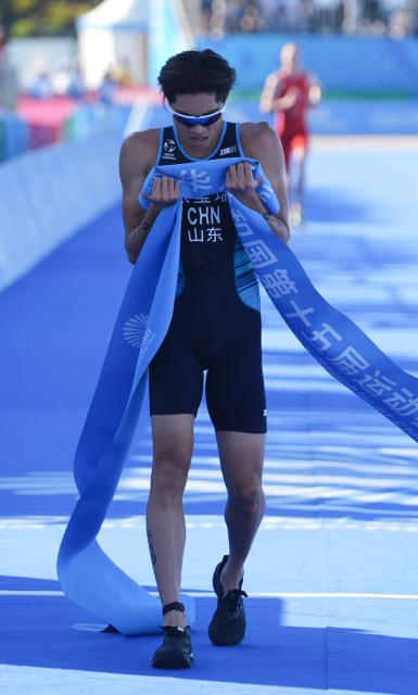 (251116) -- HONG KONG, Nov. 16, 2025 (Xinhua) -- Zhang Xirui of Shandong reacts after crossing the finish line during the triathlon mixed relay at China's 15th National Games in Hong Kong, south China, Nov. 16, 2025. (Xinhua/Lui Sui Wai)