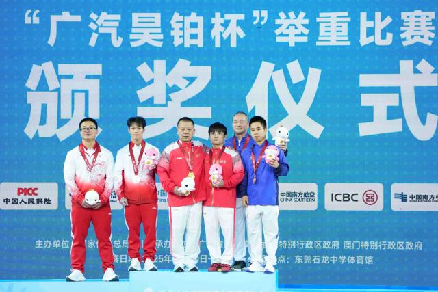 (251116) -- DONGGUAN, Nov. 16, 2025 (Xinhua) -- Gold medalist Zou Weibin of Hunan, silver medalist Wang Weidong of Guangdong and bronze medalist Yao Chen of Fujian pose with their coaches during the awarding ceremony after the weightlifting men's 55kg final at China's 15th National Games in Dongguan, south China's Guangdong Province, Nov. 16, 2025. (Xinhua/Yang Chenguang)