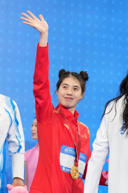 (251116) -- SHENZHEN, Nov. 16, 2025 (Xinhua) -- Gold medalist Zhang Yufei of Jiangsu greets the spectators during the awarding ceremony for the women's 50m butterfly of swimming at China's 15th National Games in Shenzhen, south China's Guangdong Province, Nov. 16, 2025. (Xinhua/Tenzin Nyida)