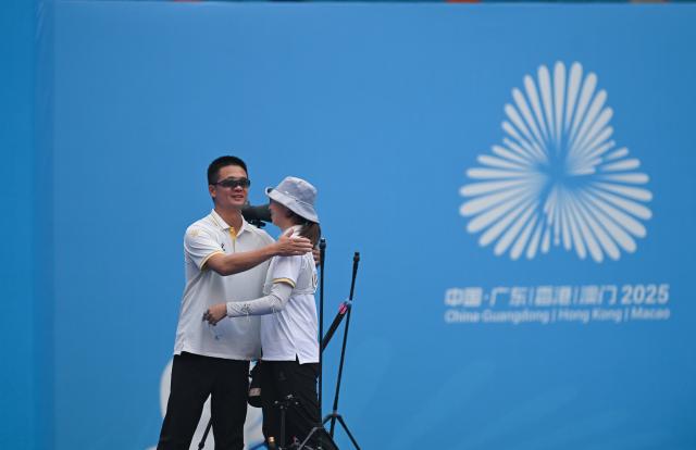 (251116) -- SHENZHEN, Nov. 16, 2025 (Xinhua) -- Zong Yu (R) of Hubei hugs her coach after winning the women's recurve individual final of archery at China's 15th National Games in Shenzhen, south China's Guangdong Province, Nov. 16, 2025. (Xinhua/Zhang Long)