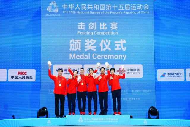(251116) -- HONG KONG, Nov. 16, 2025 (Xinhua) -- Gold medalist Yang Hengyu of Jiangsu, silver medalist Fu Ying of Jiangsu and bronze medalist Qian Jiarui of Jiangsu pose with their coaches during the awarding ceremony after the women's sabre individual final of fencing at China's 15th National Games in Hong Kong, south China, Nov. 16, 2025. (Xinhua/Zhu Wei)