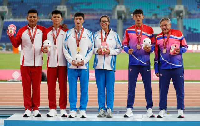(251116) -- GUANGZHOU, Nov. 16, 2025 (Xinhua) -- Gold medalist Hua Zihui of Zhejiang, silver medalist Zhang Wenxi of Shandong and bronze medalist Fei Xiang of Shanghai pose with their coaches during the awarding ceremony of the men's decathlon of athletics at China's 15th National Games in Guangzhou, south China's Guangdong Province, Nov. 16, 2025. (Xinhua/Huang Wei)